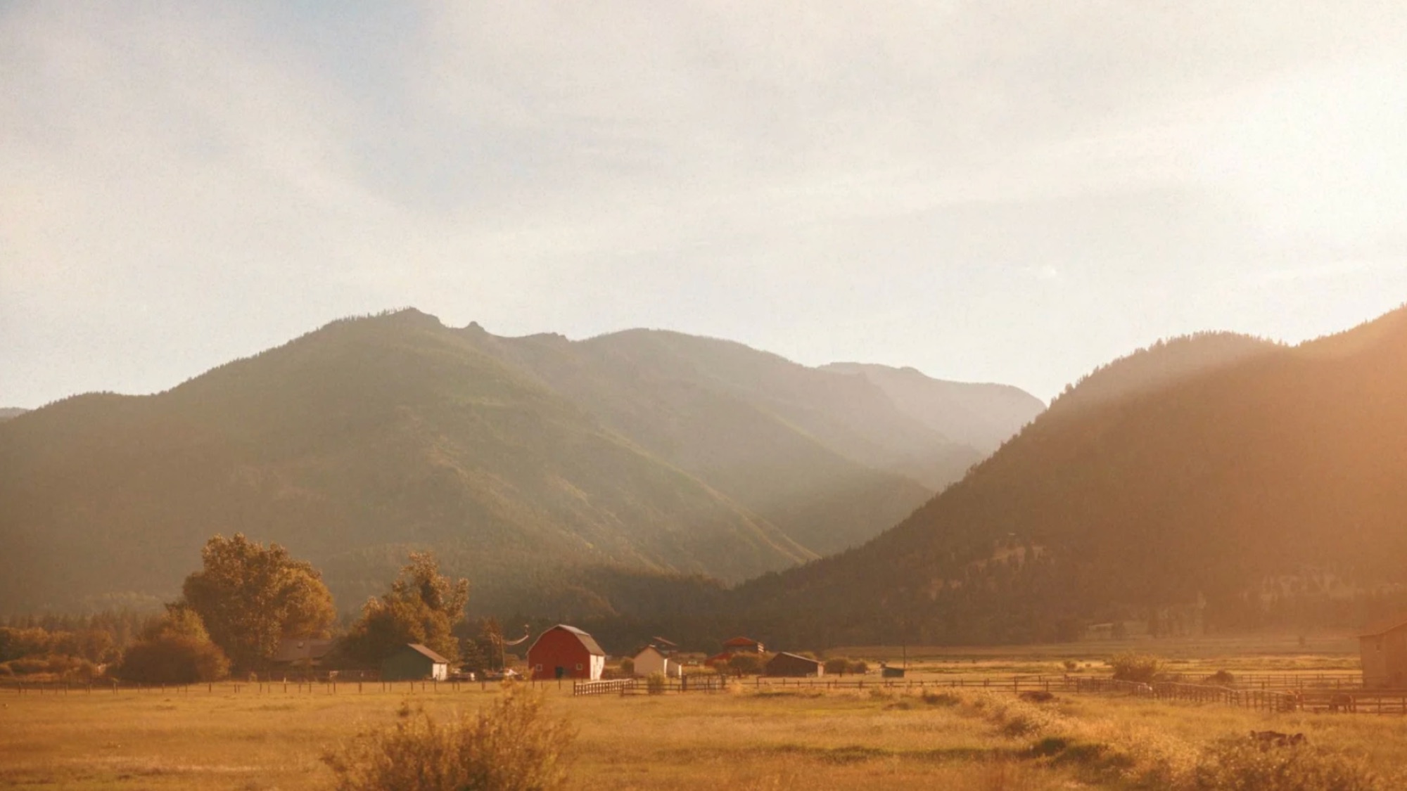 Farm buildings in a mountain valley at golden hour